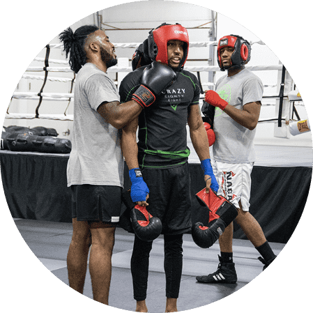 Teammate helps a boxer put on his head protection