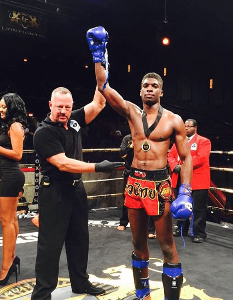 Man with arm held high, after winning a pro muay thai bout