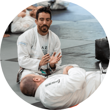 a student is lying on the ground during practice, watching instructor explain