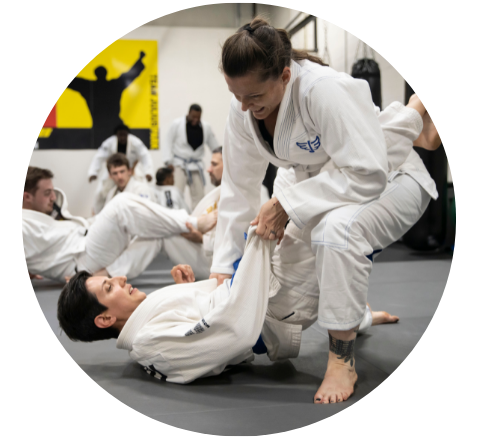 a student is lying on the ground during practice, watching instructor explain