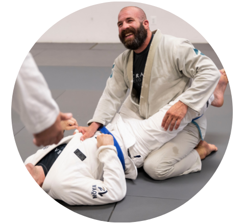 a student is lying on the ground during practice, watching instructor explain